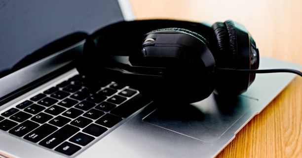 black headphone on a laptop computer.
